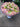 Bouquet of flowers with pink and white flowers on a gray pavement.