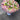 Bouquet of flowers with pink and white flowers on a gray pavement.