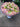 Bouquet of flowers with pink and white flowers on a gray pavement.
