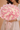 Bouquet of pink and white roses held by a person against a beige background