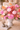 Colorful floral arrangement in a white vase on a wooden table.